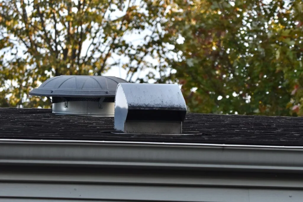 Attic vent and shingles on a home roof